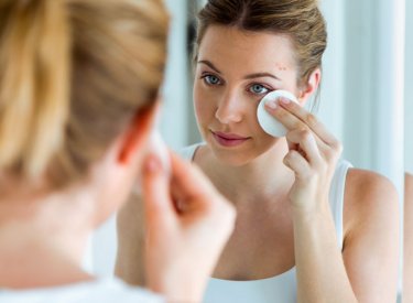 Woman with acne-prone skin cleaning her face Woman with acne-prone skin cleaning her face